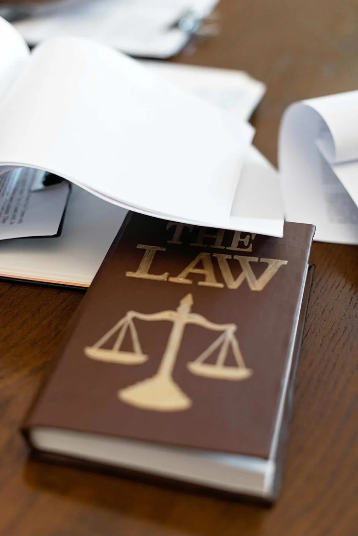 Law book and legal documents placed on a desk representing legal investigation and case analysis